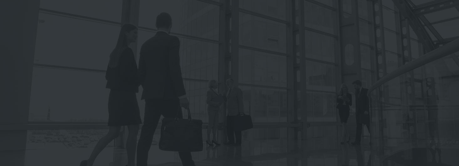 Professionals walking through the glass atrium of an office building